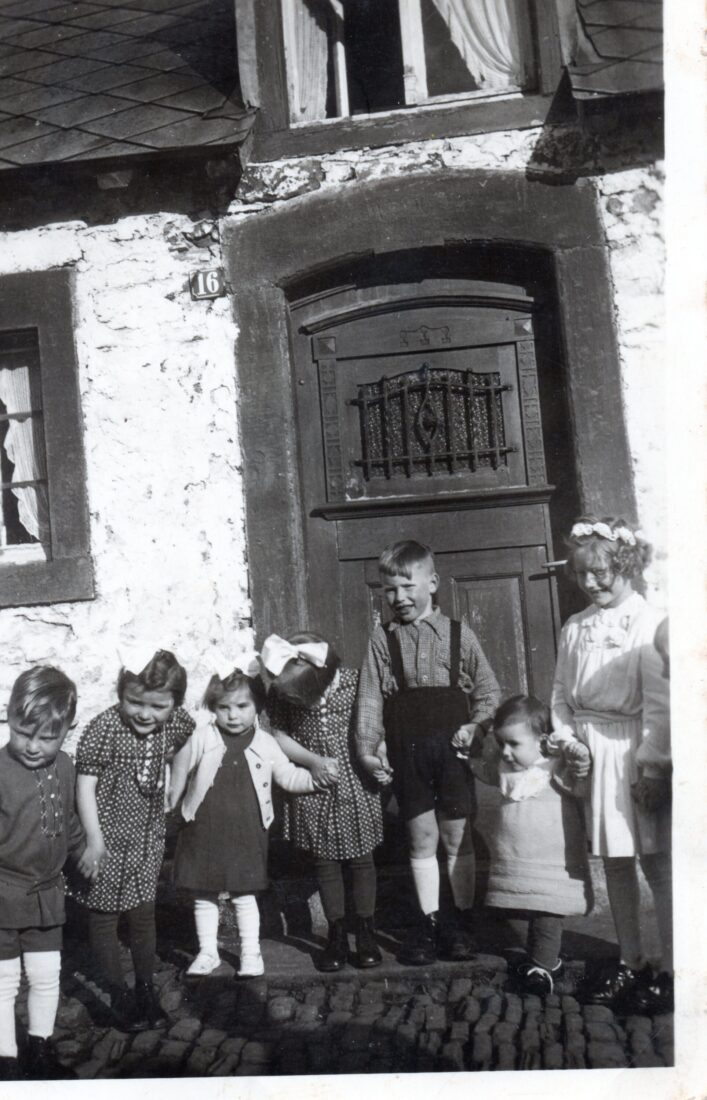 Letzte Aufnahme vor dem Haus Heenen vor dessen Zerstörung während der Ardennenoffensive. Anlass: Kommunion von Irma Brüls am 16. April 1944.